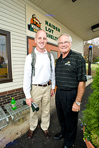 photo of president hopkins and a student at the shuttle stop