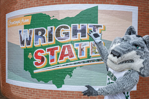 Rowdy standing infront of a wright state mural