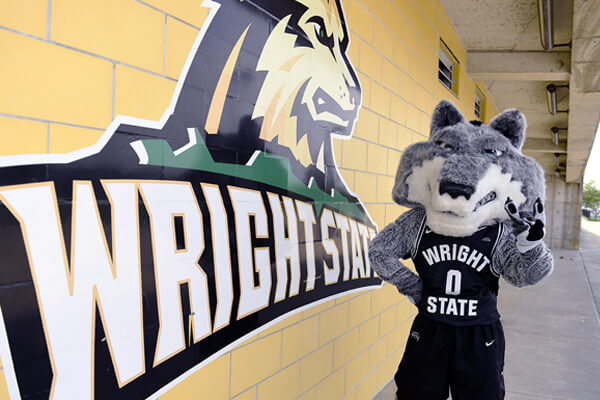 Rowdy standing in front of the wright state athletics logo
