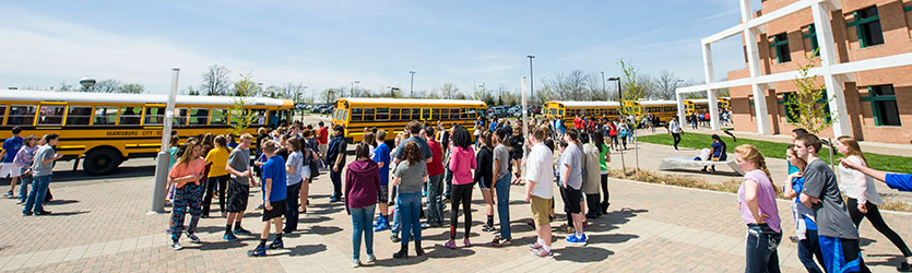 photo of children and school buses in front of the student union