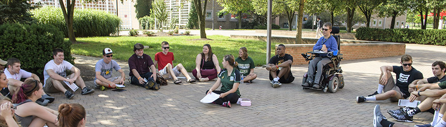 photo of students sitting in a circle outside on campus