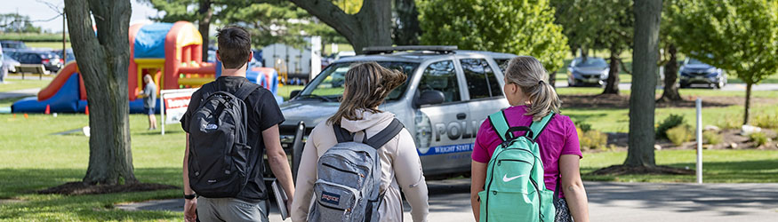 photo of students walking towards a police cruiser on campus