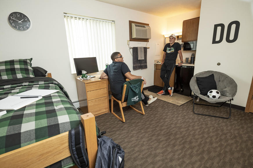photo of two students in a dorm room