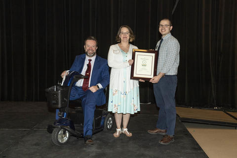 Tom Webb and Evan Mason present Ashley Mixson with a Golden Spoke Award. 