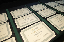 numerous scholarship certificates are laid out on a table