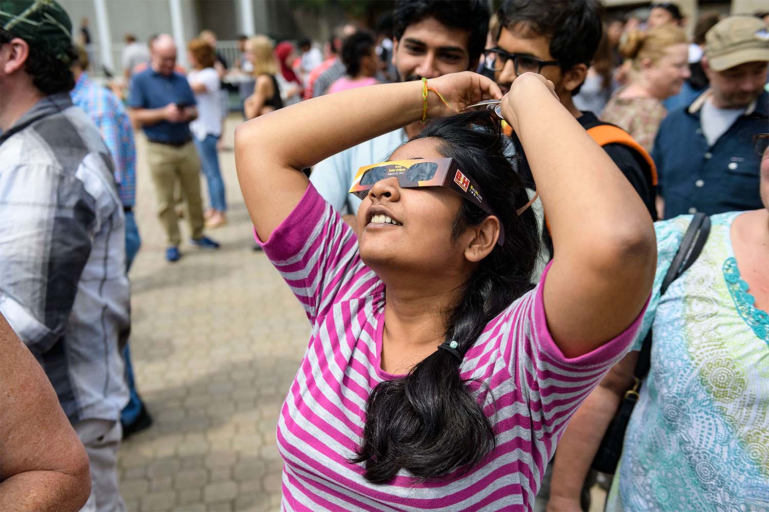 Students wearing glasses looking at a solar eclipse
