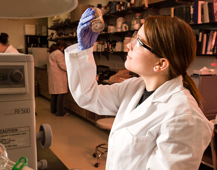 Lab student observing bottle contents
