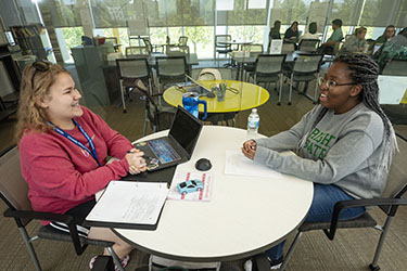photo of a student tutoring a student in the student success center