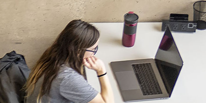 photo of a person looking at a laptop