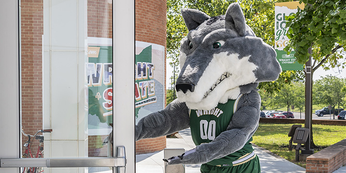 photo of rowdy holding the door open at the student union main entrance