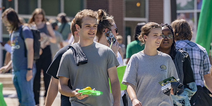 photo of students walking at an event outside on campus