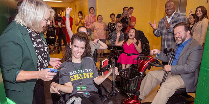 Students celebrating a new tunnel to allow them to use their handicapable motorized wheelchairs to travel on campus