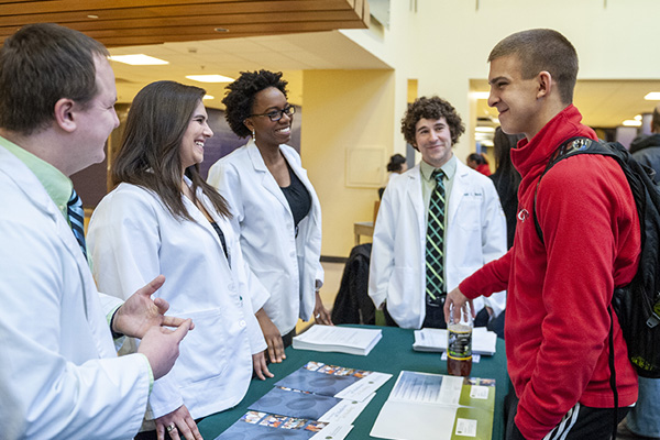 perspective student talking to health students at the event