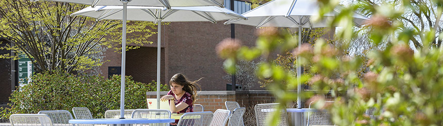 photo of a student sitting a table outside on campus