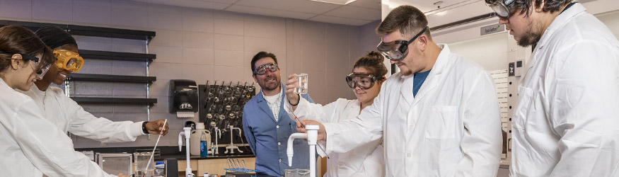photo of students and a professor in a lab