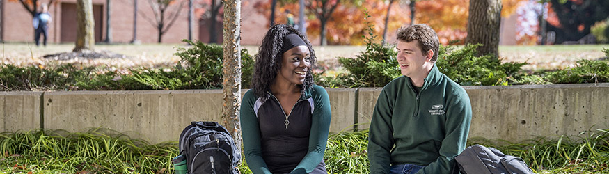 photo of students sitting outside on campus