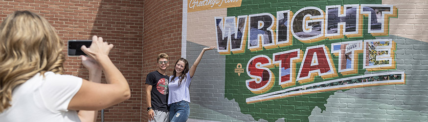 photo of students in front of the postcard mural