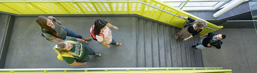 photo of students walking up and down stairs in the student success center