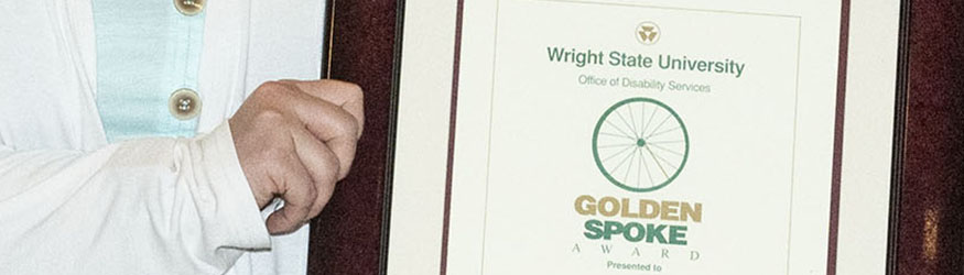 photo of a person holding a golden spoke award