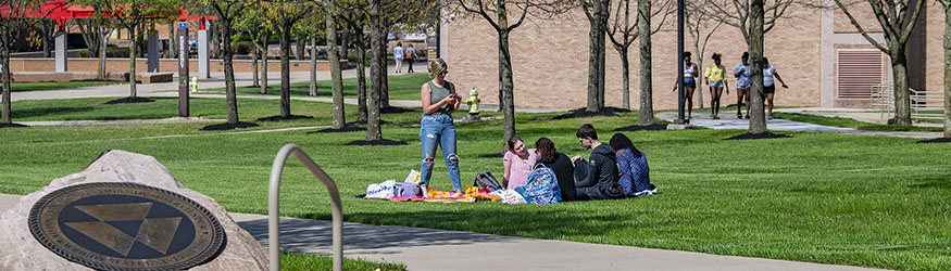 photo of students walking and sitting outside on campus