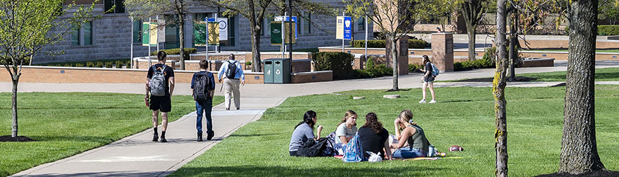 photo of students sitting and walking outside on campus