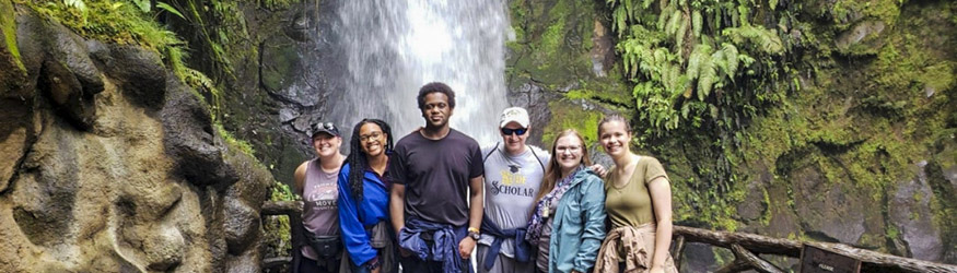 photo of a study abroad group in front of a waterfall in costa rica