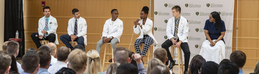 photo of a panel of speakers and an audience