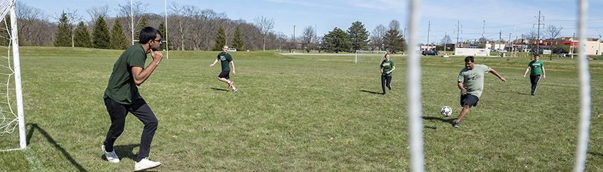 photo of students playing soccer on an outdoor field