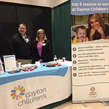Photo from Career Fair 2018 Spring Semester, featuring two recruiters behind the Dayton Children's booth display.