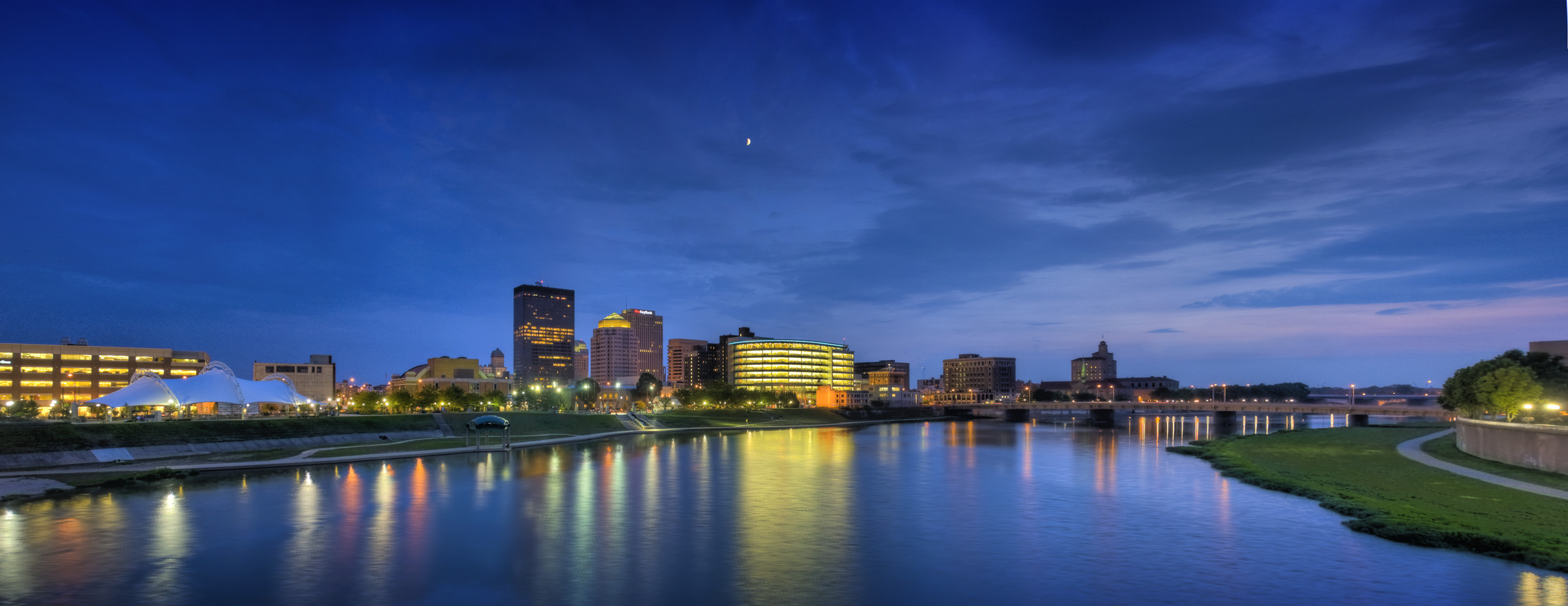 Panorama of Downtown Dayton skyline at twilight, looking across the Great Miami River near RiverScape MetroPark