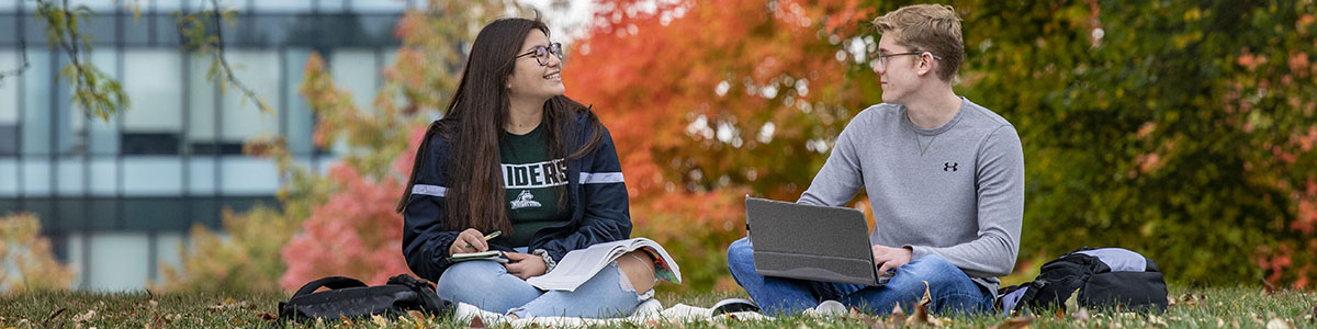 photo of students sitting outside on campus