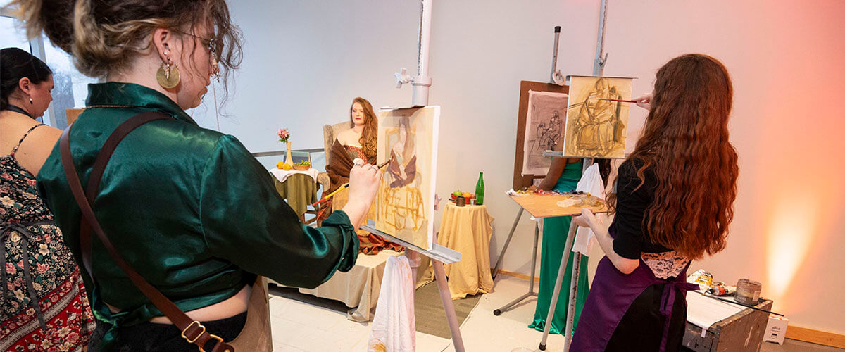 Students painting a live model at artsgala