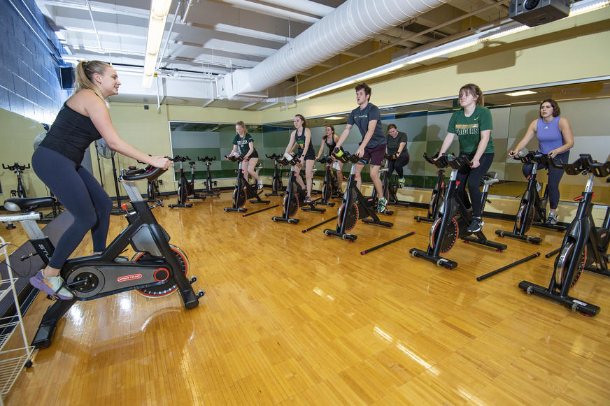 photo of an instructor and students in a cycling class