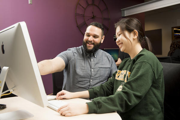 Library staff member helps student in Student Technology Assistance Center (STAC)