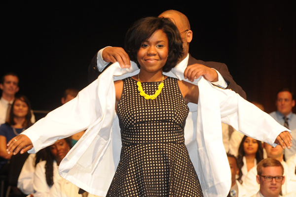 Student receiving her white coat at convocation