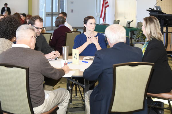 Dr. Schrader seated at table with community members.