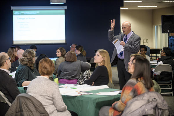 Dr. Bright talking to community members seated at tables.
