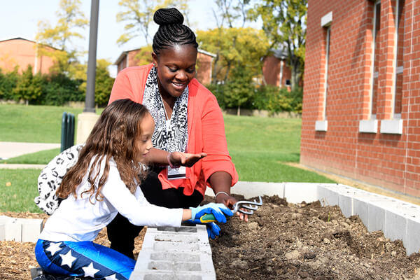 Student teaching a young child