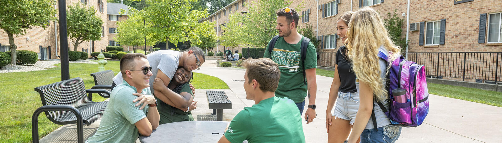 photo of students at a table outside of The Woods housing