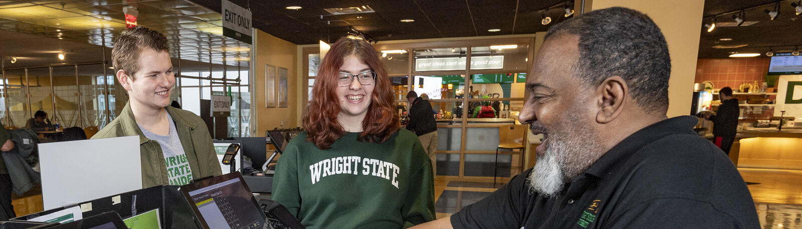 photo of students and an employee in the union market