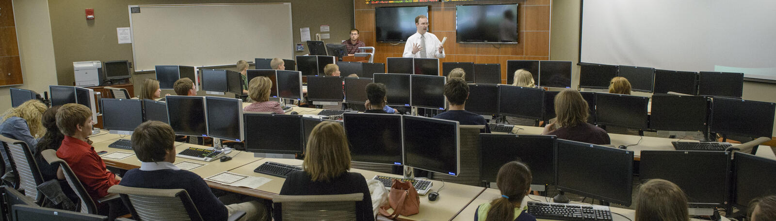 photo of students and a professor in the trading room