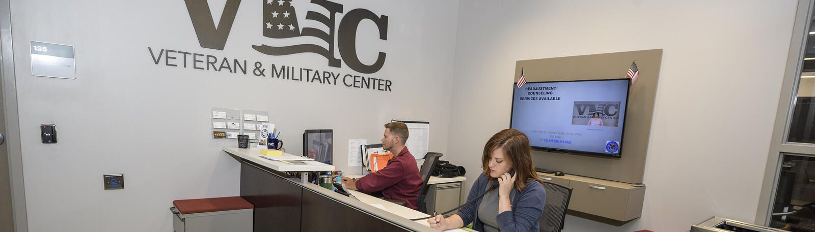 photo of students working at the front desk of the veteran and military center