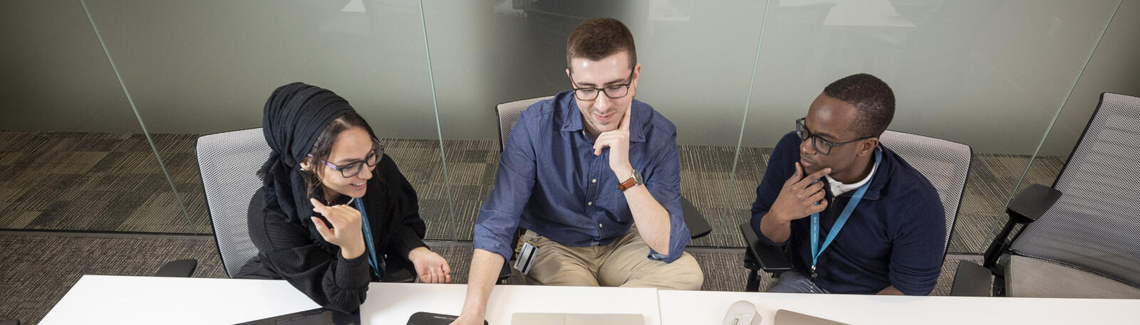 students sitting at a table with laptops