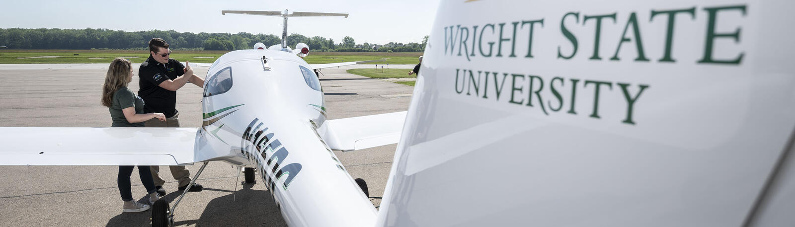 student and instructor standing by a plane