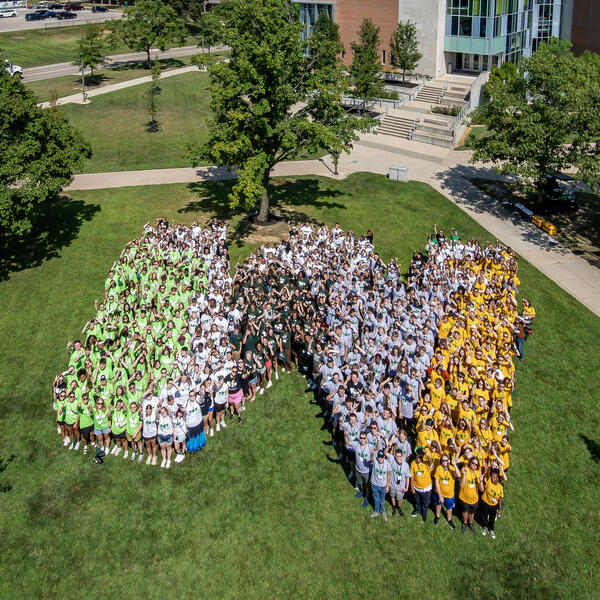 students standing in the shape of a w on campus