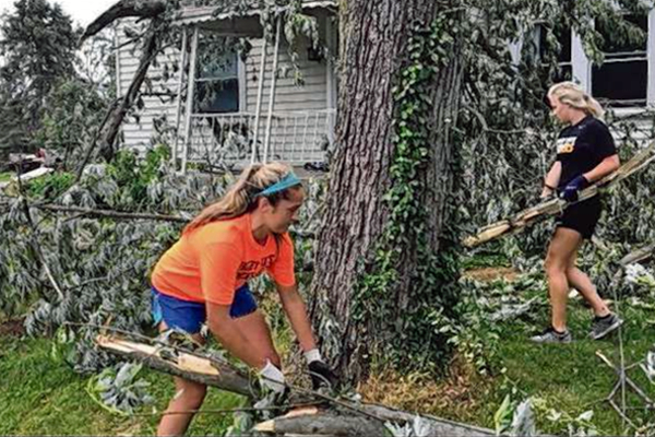 Women's soccer players cleaning up after storm