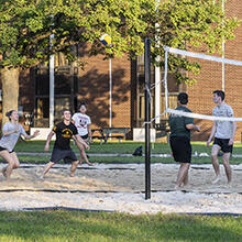 photo of students playing volleyball on campus