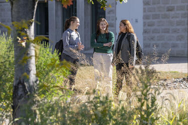 photo of students standing outside on campus talking
