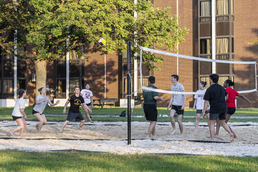 students playing volleyball on campus