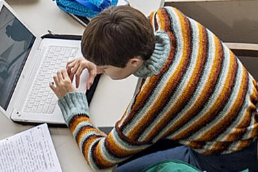 student sitting at desk using computer